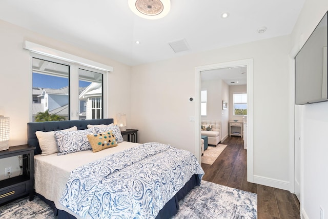 bedroom featuring dark wood-type flooring and ensuite bath