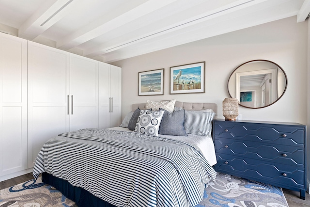 bedroom with hardwood / wood-style floors and beam ceiling