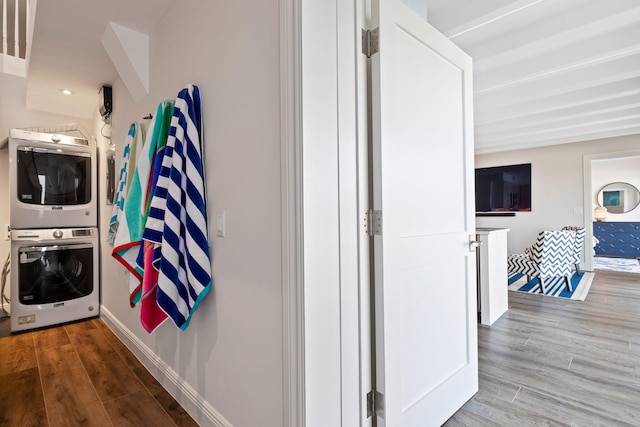 hall with stacked washer / dryer and wood-type flooring