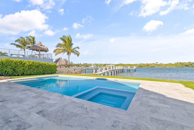 view of pool with a water view, a patio area, and an in ground hot tub