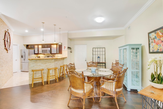 dining area featuring ornamental molding and hardwood / wood-style floors