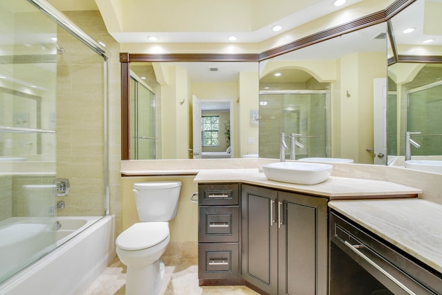 full bathroom with enclosed tub / shower combo, toilet, and vanity