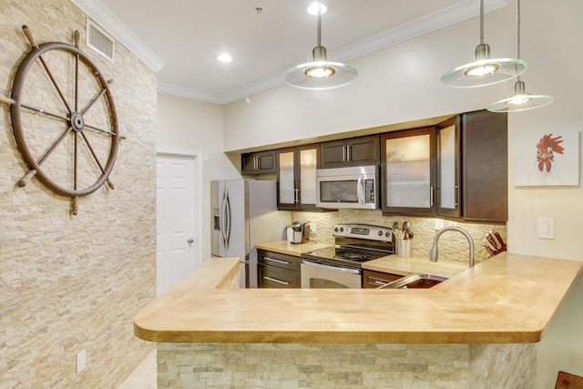 kitchen featuring visible vents, backsplash, appliances with stainless steel finishes, ornamental molding, and a sink