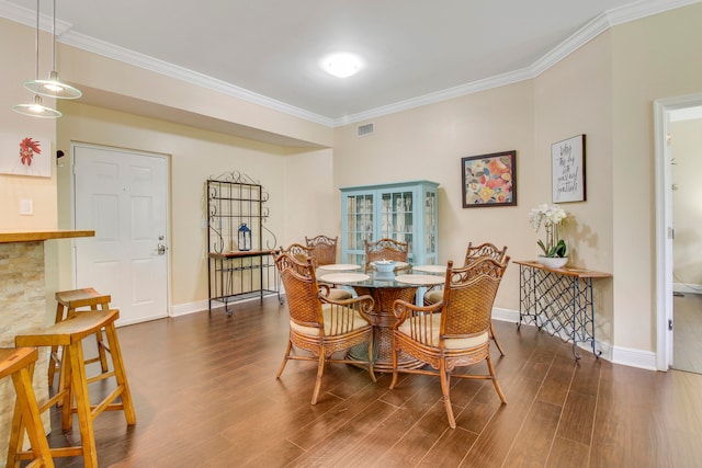 dining area featuring crown molding and dark wood-type flooring