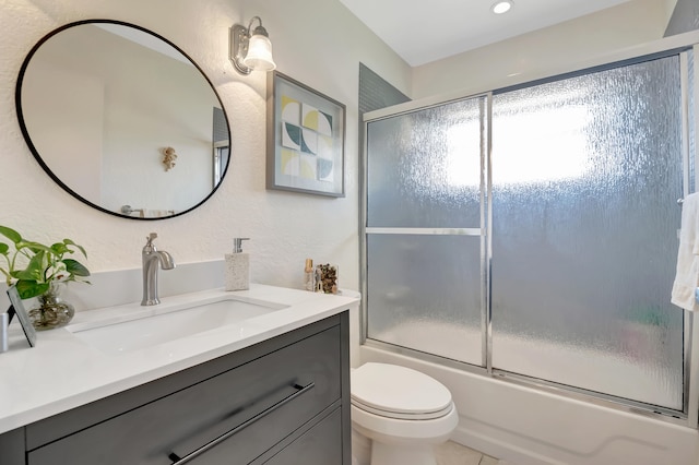 bathroom with enclosed tub / shower combo, vanity, and toilet