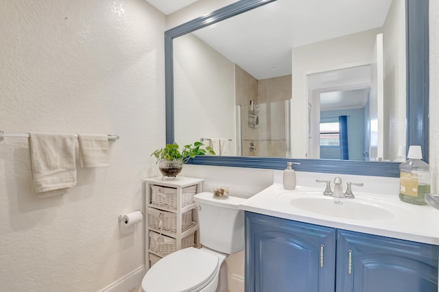 bathroom featuring a textured wall, vanity, and toilet