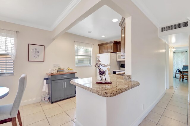 kitchen featuring a healthy amount of sunlight, crown molding, kitchen peninsula, and white refrigerator