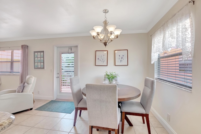 dining area with a chandelier, a wealth of natural light, crown molding, and light tile patterned floors