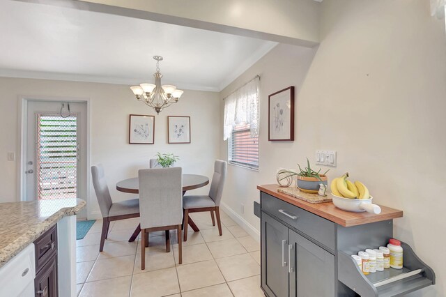 dining area featuring baseboards, ornamental molding, light tile patterned flooring, and an inviting chandelier