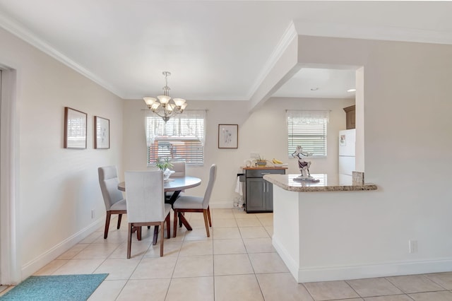 dining area with light tile patterned floors, baseboards, a chandelier, and crown molding