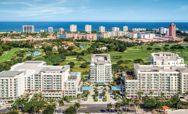 drone / aerial view with a water view, view of golf course, and a view of city