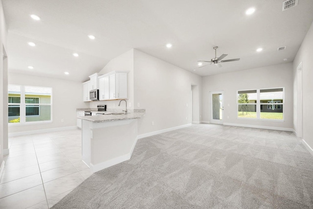 unfurnished living room featuring light colored carpet, ceiling fan, lofted ceiling, and sink