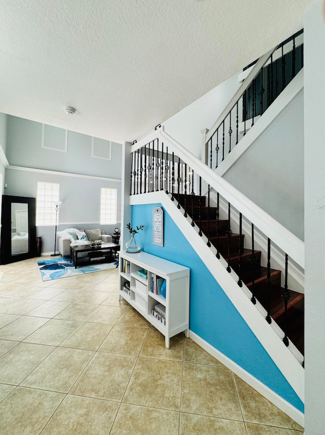 stairway with a textured ceiling and tile patterned flooring