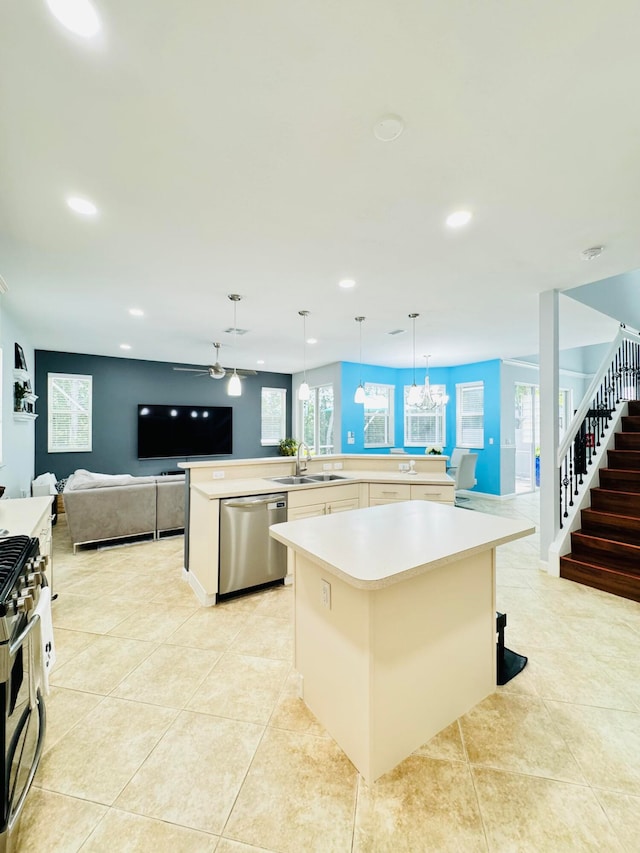 kitchen with a center island, decorative light fixtures, appliances with stainless steel finishes, sink, and a kitchen bar