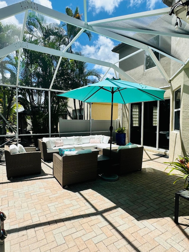 view of patio with an outdoor living space and a lanai