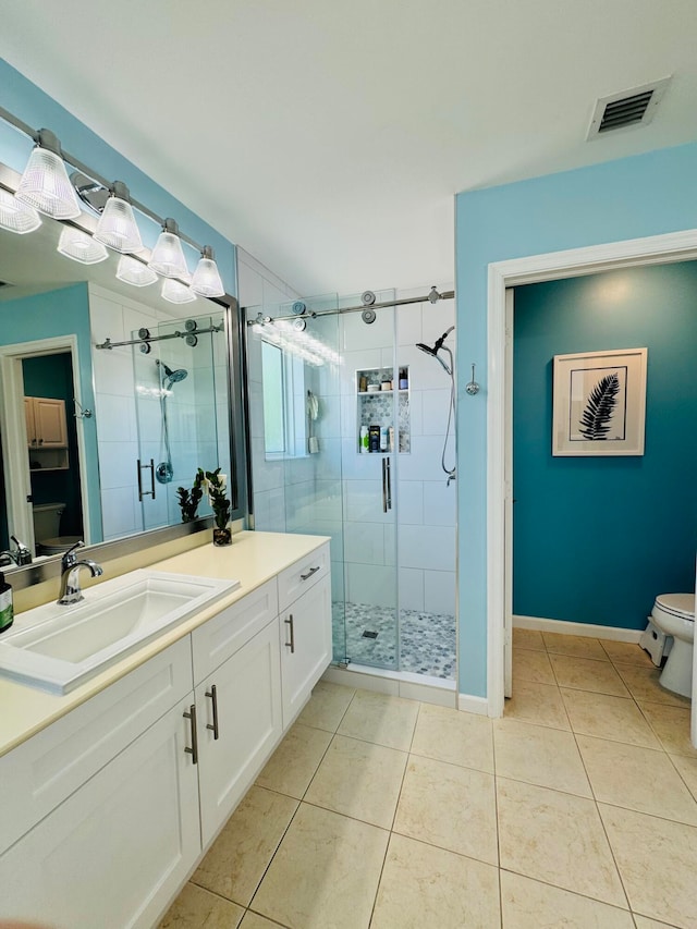 bathroom with vanity, toilet, an enclosed shower, and tile patterned floors