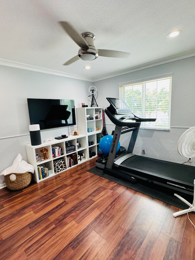 workout room featuring ornamental molding, a textured ceiling, hardwood / wood-style flooring, and ceiling fan