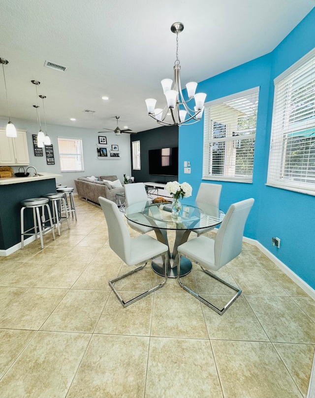 tiled dining space with ceiling fan with notable chandelier