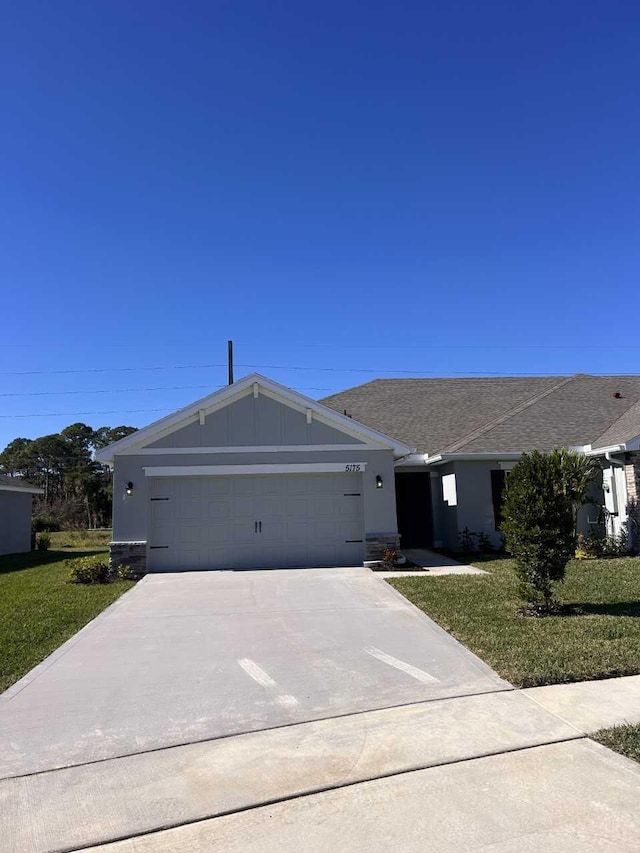 5175 Modeno St, Fort Pierce, FL 34951 - ranch-style house featuring an attached garage, driveway, board and batten siding, and a front yard