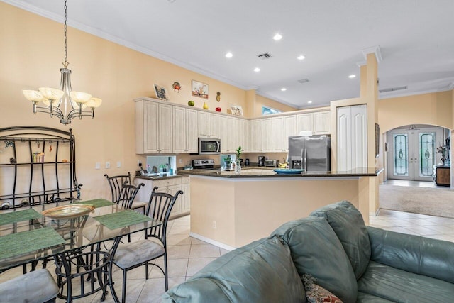 kitchen with ornamental molding, light tile patterned floors, stainless steel appliances, an inviting chandelier, and french doors