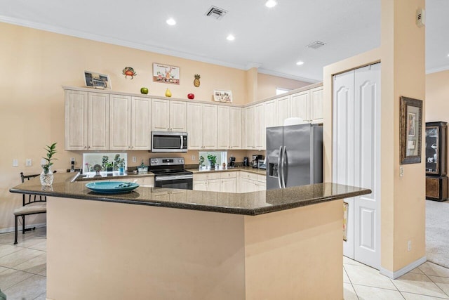 kitchen with stainless steel appliances, ornamental molding, kitchen peninsula, dark stone countertops, and light tile patterned flooring