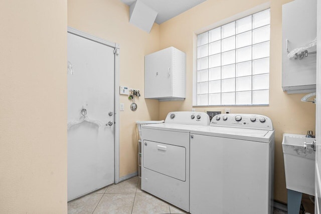 laundry area with sink, independent washer and dryer, and light tile patterned flooring