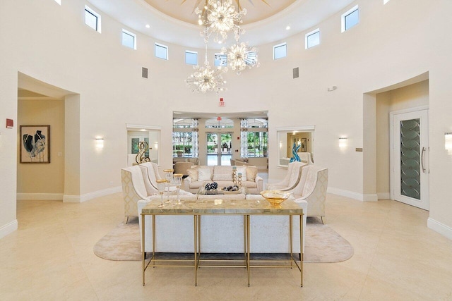 tiled living room with a raised ceiling, a high ceiling, an inviting chandelier, and french doors