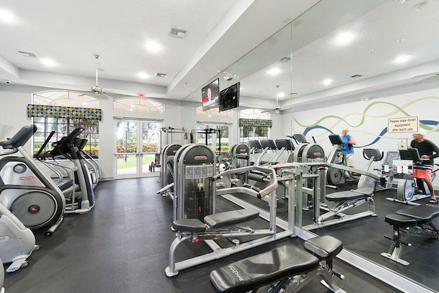 workout area featuring a textured ceiling, ceiling fan, and french doors