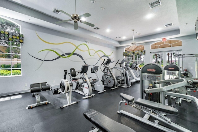 gym featuring a textured ceiling, plenty of natural light, ceiling fan, and french doors