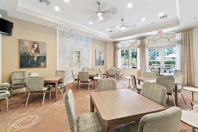 dining space with a tray ceiling, ceiling fan, crown molding, and a textured ceiling