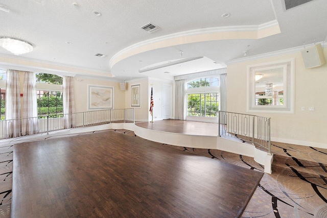 unfurnished living room featuring crown molding, hardwood / wood-style flooring, and a tray ceiling