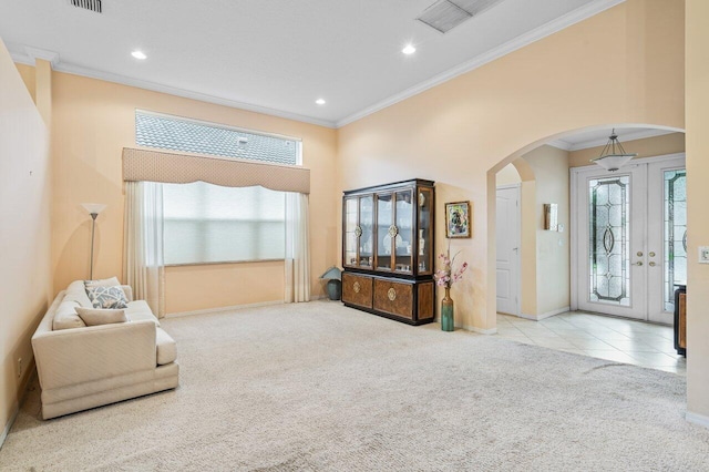 living room with light carpet, ornamental molding, and a high ceiling