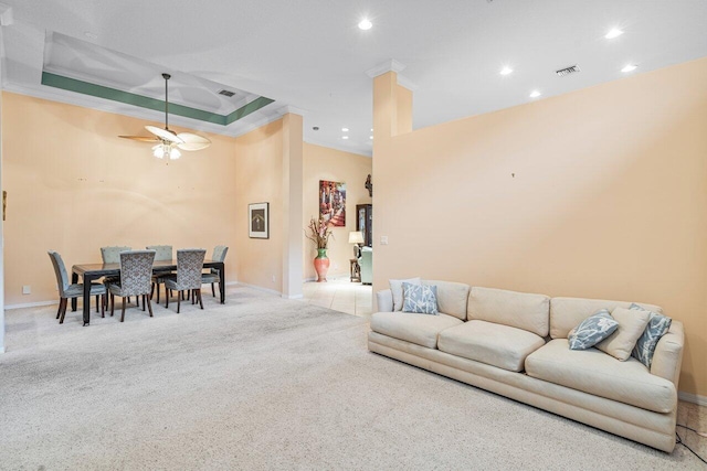 carpeted living room featuring a tray ceiling, ceiling fan, and crown molding