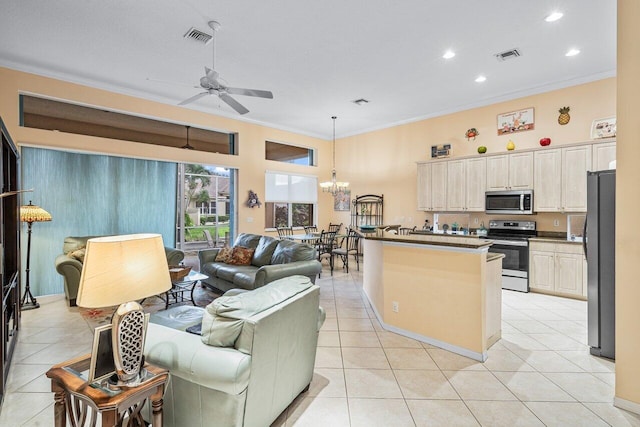 kitchen with ceiling fan with notable chandelier, ornamental molding, light tile patterned floors, decorative light fixtures, and appliances with stainless steel finishes