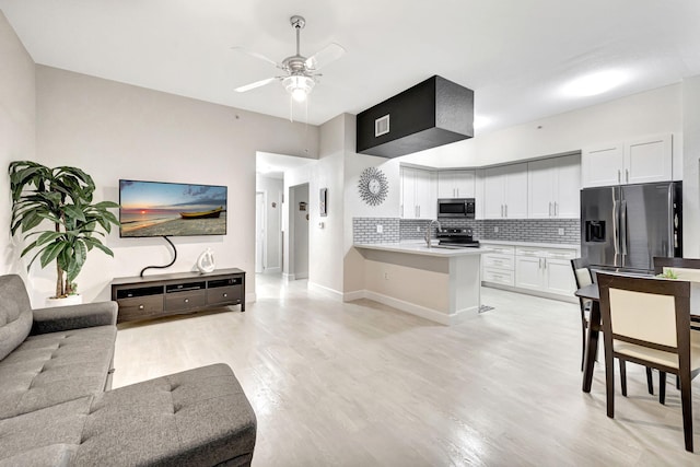 kitchen with backsplash, ceiling fan, appliances with stainless steel finishes, white cabinetry, and kitchen peninsula