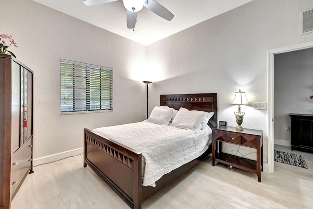 bedroom with ceiling fan, ensuite bathroom, and light hardwood / wood-style flooring