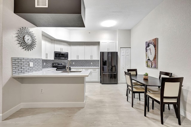 2801 Riverside Dr Unit 203-S, Coral Springs, FL 33065 - kitchen featuring stainless steel appliances, a sink, tasteful backsplash, light countertops, and a peninsula