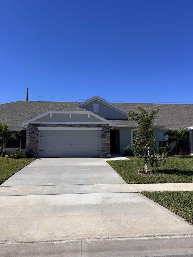 ranch-style home with a garage and a front lawn