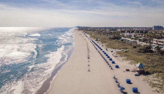 aerial view with a water view and a beach view