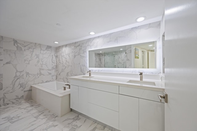 bathroom with vanity, shower with separate bathtub, and tile walls