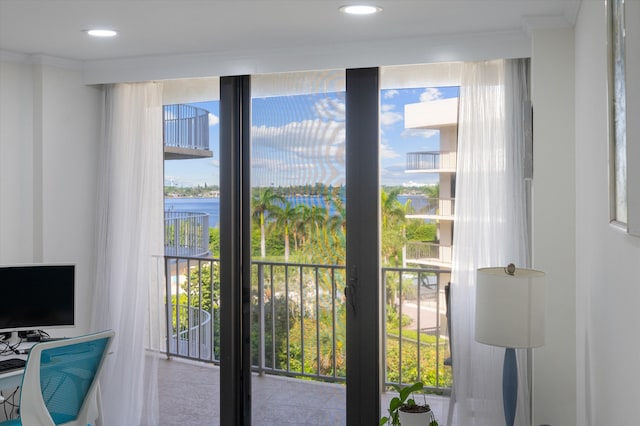 doorway to outside with a water view and crown molding