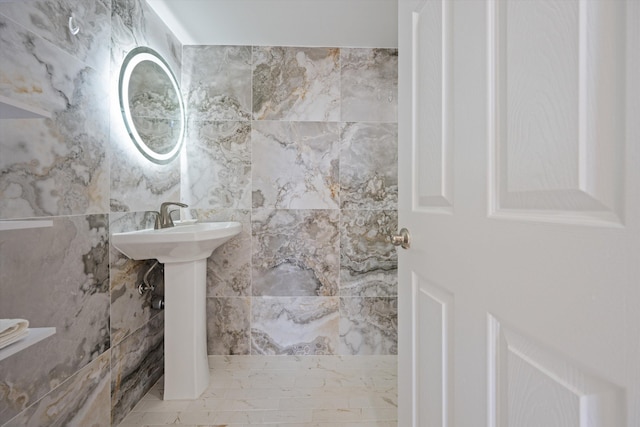 bathroom with tile walls and sink