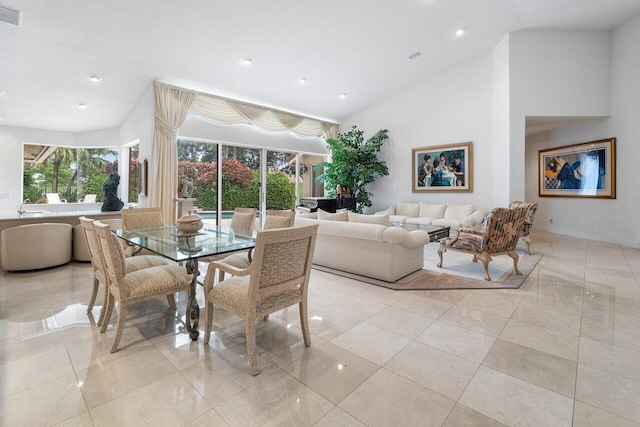 dining room featuring light tile patterned floors, high vaulted ceiling, and a wealth of natural light