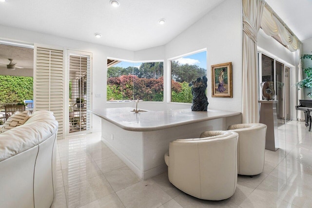 bathroom featuring ceiling fan, a washtub, and tile patterned flooring