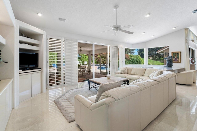 living room with vaulted ceiling, a textured ceiling, and ceiling fan