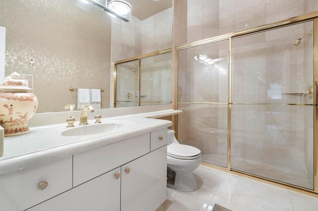 bathroom with vanity, toilet, tile patterned floors, and a shower with door