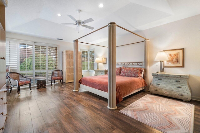 bedroom with lofted ceiling, ceiling fan, a tray ceiling, and dark hardwood / wood-style flooring