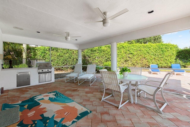 view of patio with exterior kitchen, area for grilling, and ceiling fan