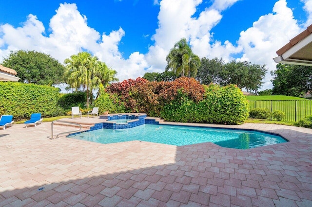 view of pool with a patio area and an in ground hot tub