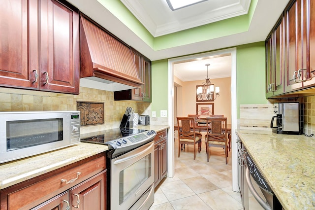 kitchen featuring appliances with stainless steel finishes, backsplash, premium range hood, and a notable chandelier